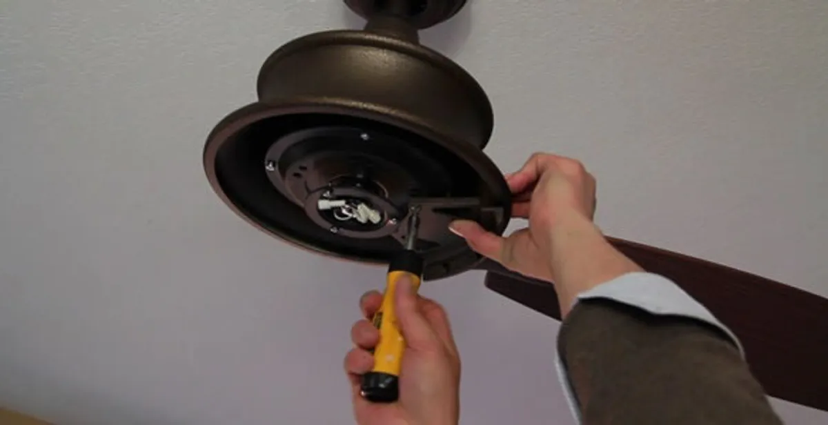 Electrician installing ceiling fan mounting bracket and fixture in San Antonio, TX